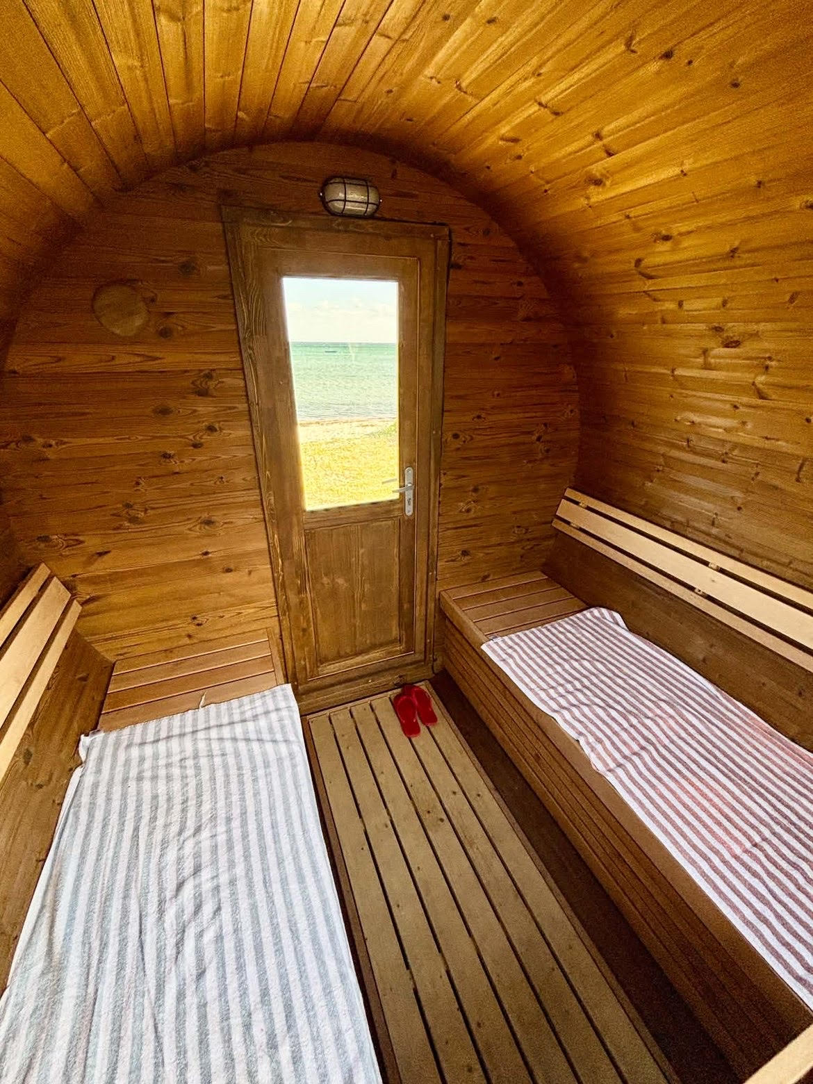 Rummeligt indvendigt kig i SaunaSetup sauna med havudsigt gennem døren